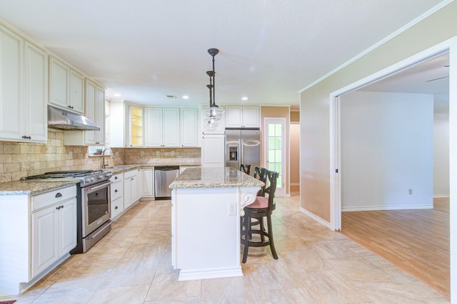 1708 Capstan Rd, Houston, TX 77062 - kitchen featuring stainless steel appliances, under cabinet range hood, a sink, a breakfast bar area, and decorative backsplash