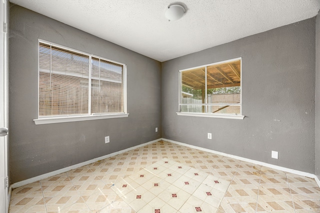 18627 Spinney Lane Dr, Cypress, TX 77433 - empty room featuring a textured ceiling, baseboards, and light floors