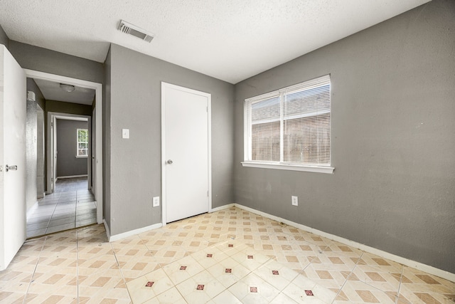 18627 Spinney Lane Dr, Cypress, TX 77433 - unfurnished bedroom featuring baseboards, a textured ceiling, and light tile patterned flooring