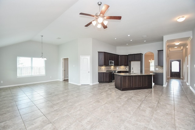 11819 Eagle Ridge Dr, Mont Belvieu, TX 77535 - kitchen with stainless steel appliances, open floor plan, decorative backsplash, light tile patterned flooring, and arched walkways