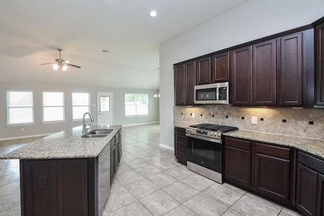 11819 Eagle Ridge Dr, Mont Belvieu, TX 77535 - kitchen with stainless steel appliances, open floor plan, a sink, light tile patterned floors, and baseboards