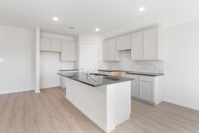 4609 Peony Green Dr, Katy, TX 77493 - kitchen with a center island with sink, light wood-type flooring, decorative backsplash, recessed lighting, and white cabinets