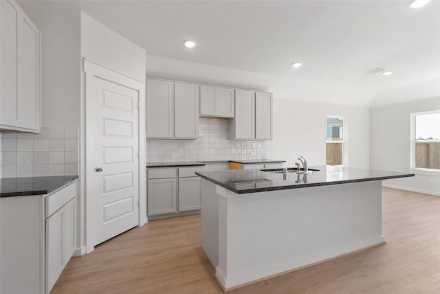 4609 Peony Green Dr, Katy, TX 77493 - kitchen featuring light wood-type flooring, decorative backsplash, a kitchen island with sink, and recessed lighting