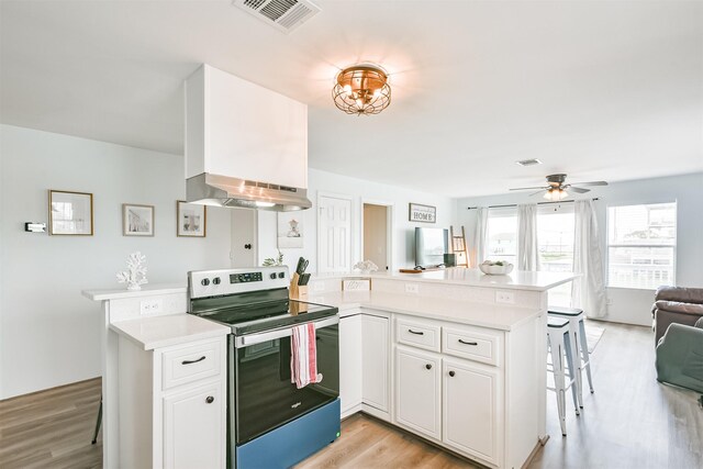 1004 20th St, Dickinson, TX 77539 - kitchen featuring stainless steel electric range, a peninsula, open floor plan, and light countertops