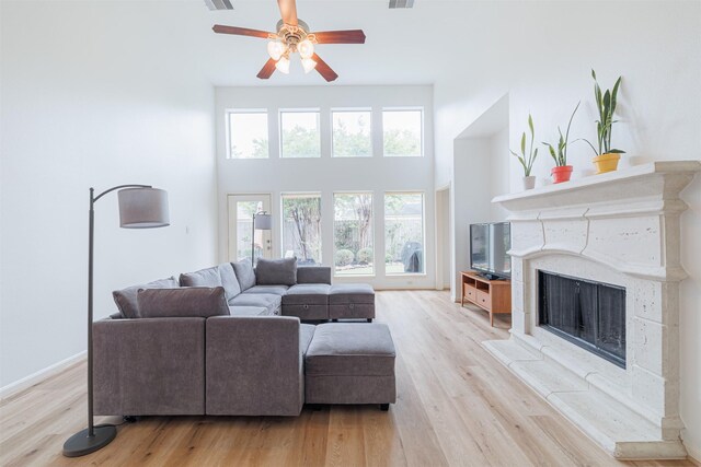 26122 Savory Springs Ln, Katy, TX 77494 - living area featuring a ceiling fan, wood finished floors, a premium fireplace, and a high ceiling