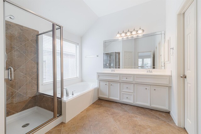 26122 Savory Springs Ln, Katy, TX 77494 - bathroom featuring vaulted ceiling, a bath, double vanity, and a stall shower