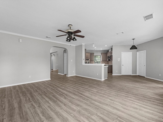 20211 Sunrise Glen Ct, Spring, TX 77379 - unfurnished living room with ceiling fan, arched walkways, baseboards, wood finished floors, and crown molding