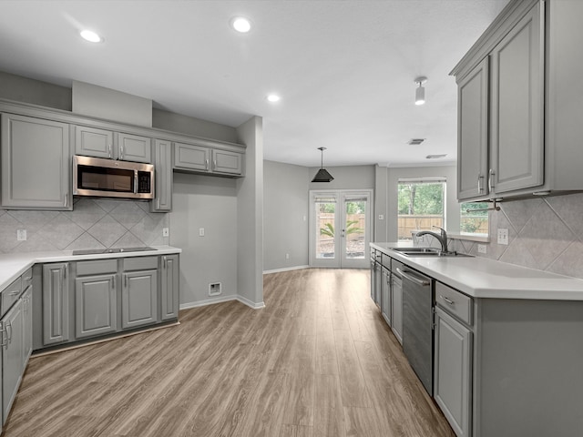 20211 Sunrise Glen Ct, Spring, TX 77379 - kitchen featuring gray cabinetry, appliances with stainless steel finishes, light wood-style flooring, decorative backsplash, and recessed lighting