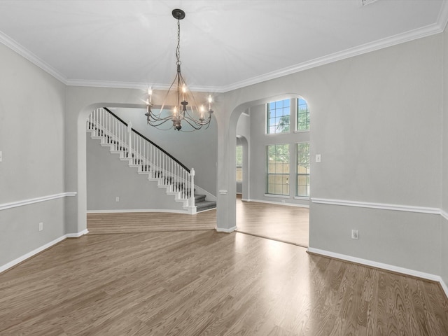 20211 Sunrise Glen Ct, Spring, TX 77379 - spare room with arched walkways, stairway, wood finished floors, a chandelier, and ornamental molding