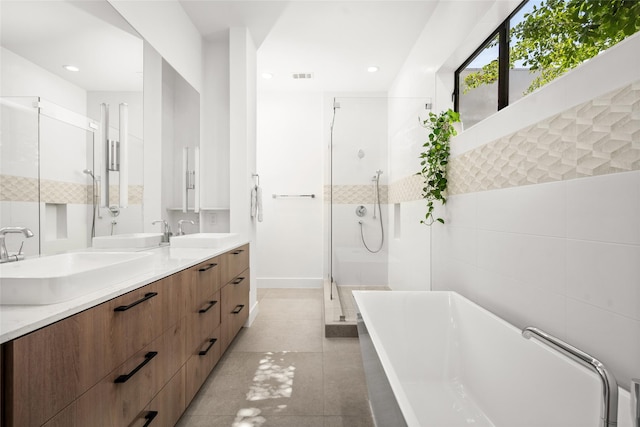 509 W Drew St, Houston, TX 77006 - full bath with a soaking tub, double vanity, a stall shower, tile patterned flooring, and recessed lighting