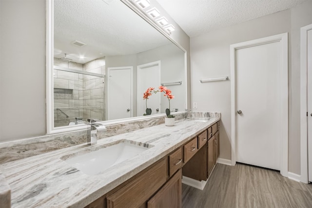 22519 Elkana Deane Ln, Katy, TX 77449 - full bath with a textured ceiling, a stall shower, wood finished floors, double vanity, and baseboards