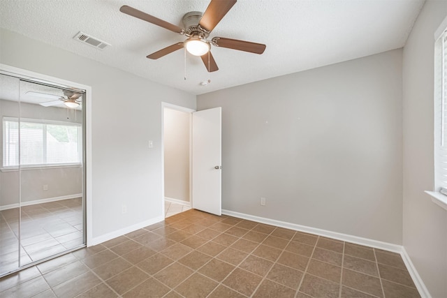 22519 Elkana Deane Ln, Katy, TX 77449 - unfurnished bedroom with tile patterned floors, a closet, a textured ceiling, a ceiling fan, and baseboards