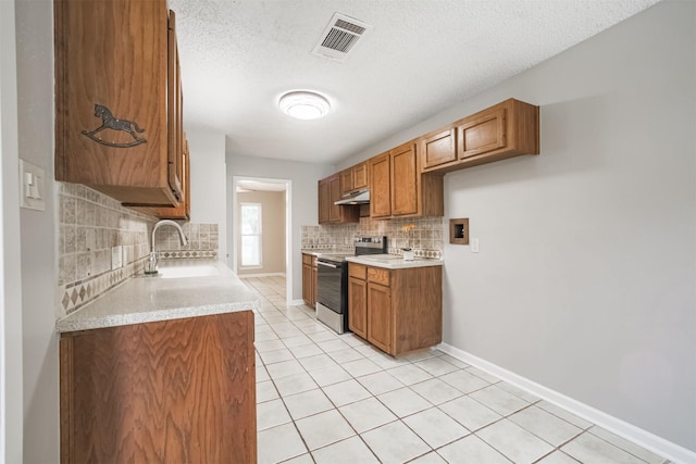 22519 Elkana Deane Ln, Katy, TX 77449 - kitchen featuring range with electric cooktop, a sink, backsplash, brown cabinets, and under cabinet range hood