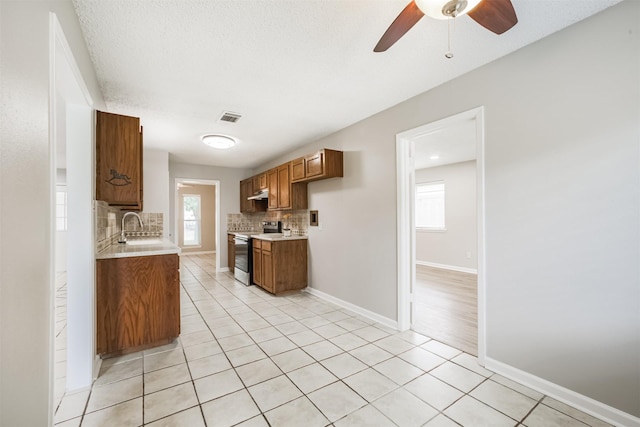 22519 Elkana Deane Ln, Katy, TX 77449 - kitchen featuring stainless steel range with electric stovetop, light countertops, backsplash, and healthy amount of natural light