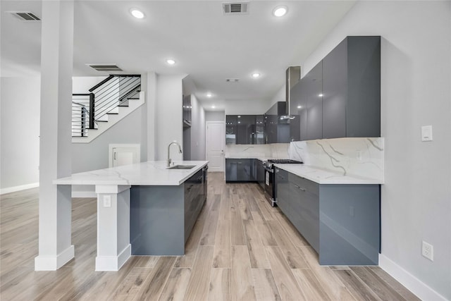 4923 Golden Forest St Unit A, Houston, TX 77091 - kitchen featuring modern cabinets, stainless steel gas range oven, a sink, gray cabinets, and recessed lighting