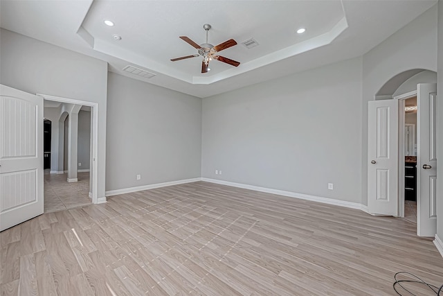 30806 Academy Trace Dr, Spring, TX 77386 - spare room featuring arched walkways, a tray ceiling, ceiling fan, recessed lighting, and light wood-type flooring
