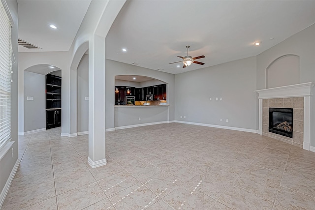 30806 Academy Trace Dr, Spring, TX 77386 - unfurnished living room with ceiling fan, a tiled fireplace, light tile patterned floors, recessed lighting, and baseboards