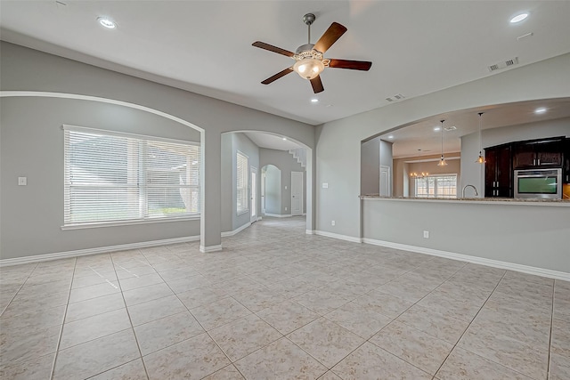 30806 Academy Trace Dr, Spring, TX 77386 - unfurnished living room with light tile patterned floors, ceiling fan, recessed lighting, arched walkways, and baseboards