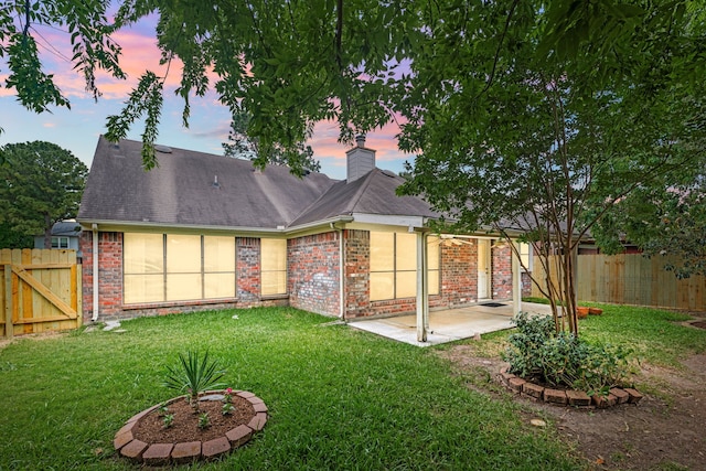 3031 W Cedar Sun Trl, Katy, TX 77449 - back of property at dusk with a patio, brick siding, a chimney, and a gate