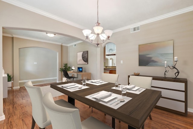 10502 Ginger Gln, Missouri City, TX 77459 - dining room with arched walkways, a chandelier, wood finished floors, crown molding, and baseboards