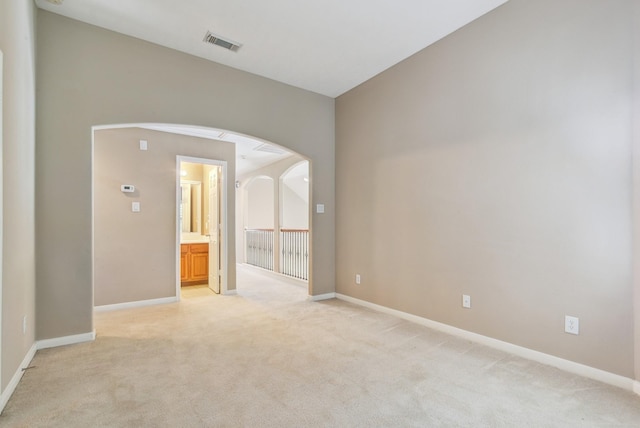 10502 Ginger Gln, Missouri City, TX 77459 - empty room featuring light carpet, arched walkways, and baseboards