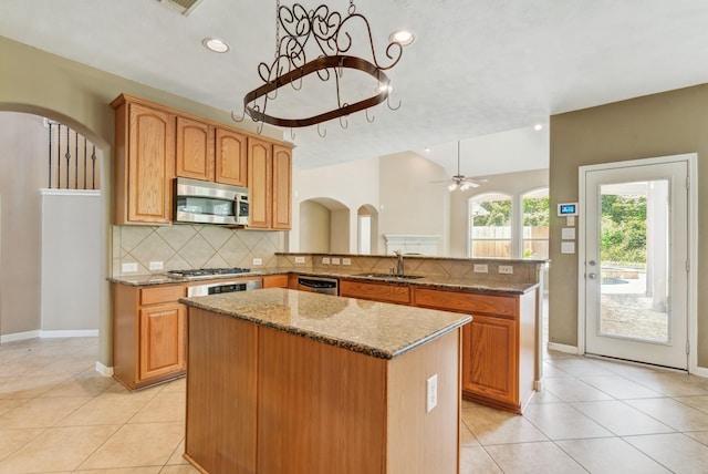 10502 Ginger Gln, Missouri City, TX 77459 - kitchen featuring appliances with stainless steel finishes, a kitchen island, light tile patterned flooring, tasteful backsplash, and recessed lighting