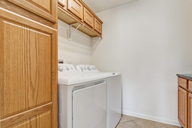 10502 Ginger Gln, Missouri City, TX 77459 - laundry room featuring washer and clothes dryer, light tile patterned floors, baseboards, and cabinet space