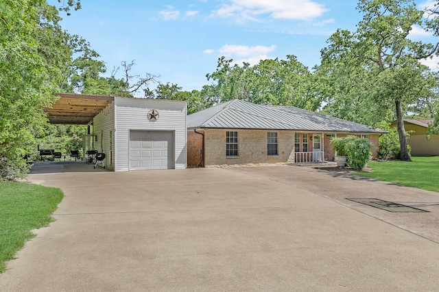 36 Jamaica Ln, Normangee, TX 77871 - view of front of property featuring concrete driveway, a garage, a carport, an outdoor structure, and stone siding