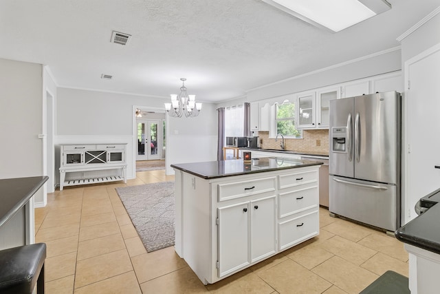 36 Jamaica Ln, Normangee, TX 77871 - kitchen with stainless steel refrigerator with ice dispenser, a chandelier, dark countertops, light tile patterned floors, and ornamental molding