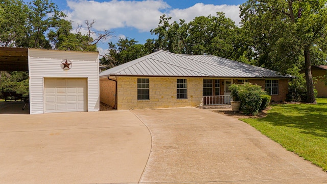 36 Jamaica Ln, Normangee, TX 77871 - view of front of home with a front lawn, concrete driveway, a garage, metal roof, and an outbuilding