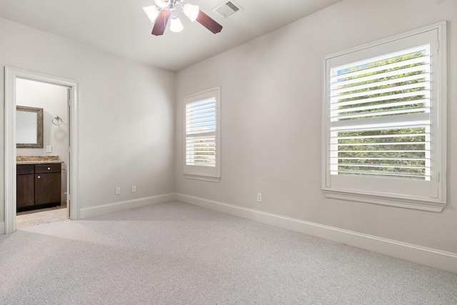 5935 Kansas St, Houston, TX 77007 - unfurnished bedroom with light colored carpet, baseboards, connected bathroom, and ceiling fan