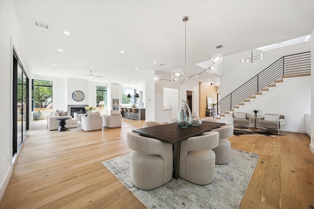 3851 Merrick St, Houston, TX 77025 - dining room with stairway, light wood-type flooring, a chandelier, recessed lighting, and a ceiling fan
