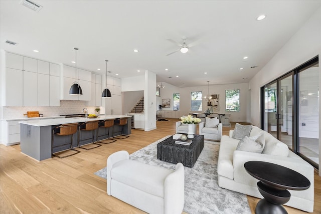 3851 Merrick St, Houston, TX 77025 - living room featuring light wood finished floors, recessed lighting, stairway, and ceiling fan