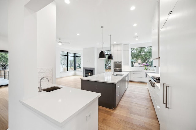 3851 Merrick St, Houston, TX 77025 - kitchen featuring a sink, modern cabinets, a kitchen island with sink, healthy amount of natural light, and recessed lighting