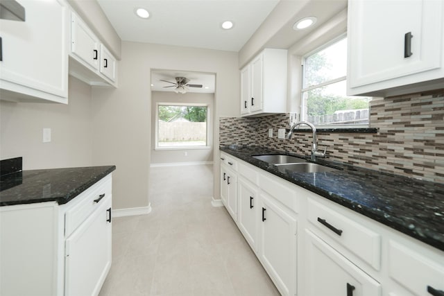 9607 Rumbling Wood Ln, Houston, TX 77086 - kitchen featuring a sink, a ceiling fan, baseboards, decorative backsplash, and dark stone counters