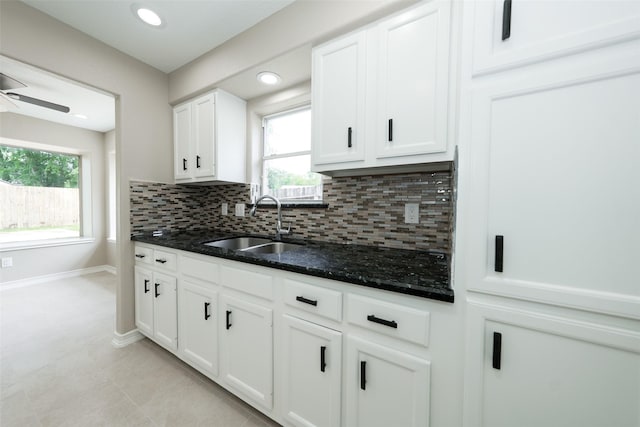 9607 Rumbling Wood Ln, Houston, TX 77086 - kitchen featuring a sink, decorative backsplash, dark stone countertops, white cabinetry, and recessed lighting