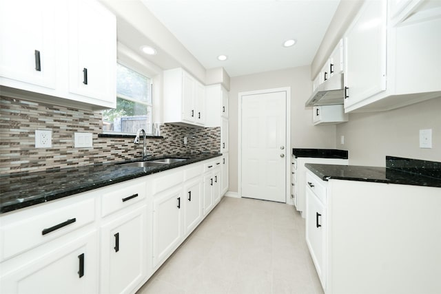 9607 Rumbling Wood Ln, Houston, TX 77086 - kitchen with a sink, under cabinet range hood, backsplash, dark stone counters, and recessed lighting