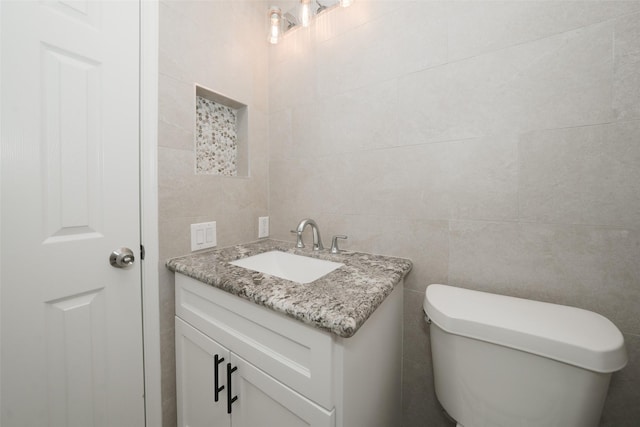 9607 Rumbling Wood Ln, Houston, TX 77086 - half bath featuring tile walls, vanity, and toilet