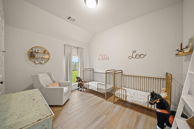 19002 Valentine Padlock Cir, Tomball, TX 77377 - bedroom featuring light wood finished floors, vaulted ceiling, and a nursery area