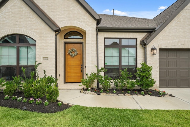 19002 Valentine Padlock Cir, Tomball, TX 77377 - property entrance with an attached garage, brick siding, a shingled roof, and concrete driveway