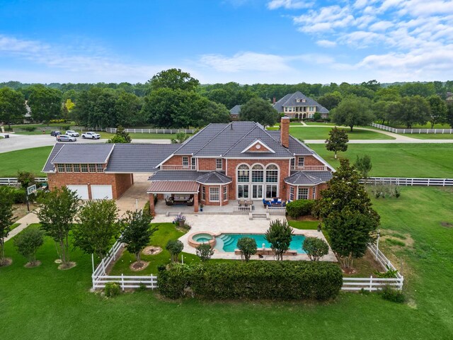 3818 Foolish Pleasure Ct, Richmond, TX 77406 - back of house featuring a chimney, brick siding, a patio, and a pool with connected hot tub