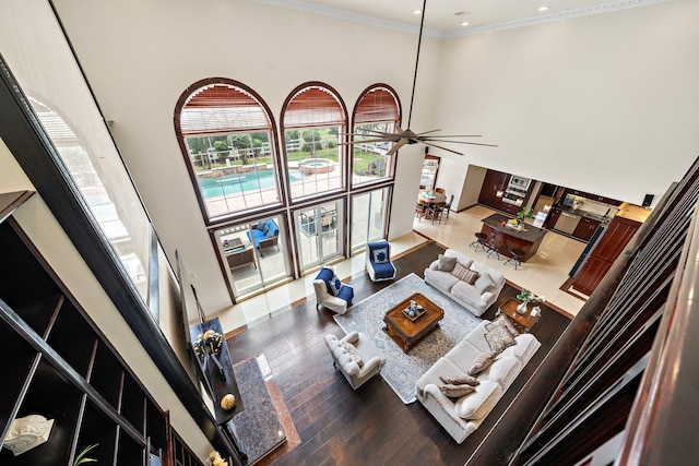 3818 Foolish Pleasure Ct, Richmond, TX 77406 - living room featuring a towering ceiling, ceiling fan, wood finished floors, recessed lighting, and ornamental molding