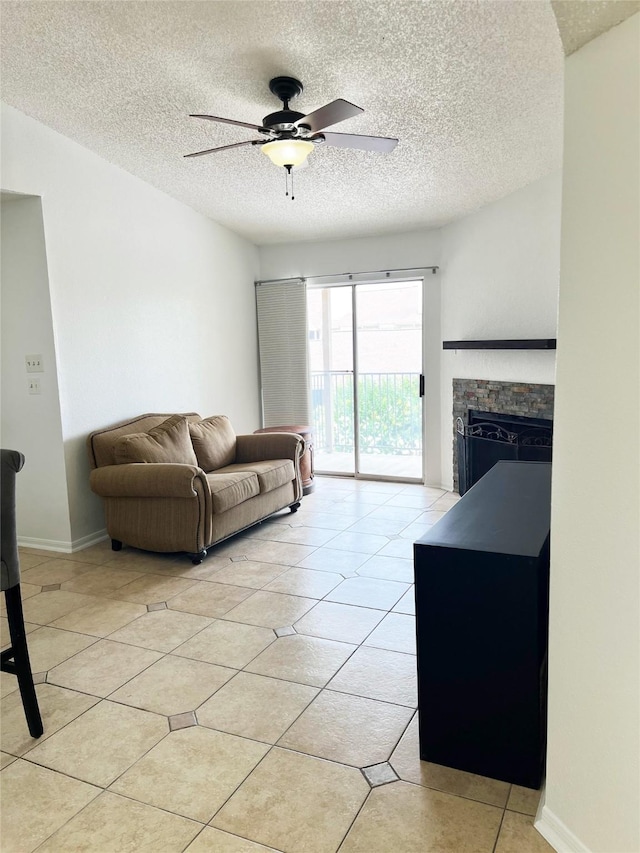 12550 Whittington Dr Unit 712, Houston, TX 77077 - living area featuring a textured ceiling, light tile patterned floors, a ceiling fan, a fireplace, and baseboards