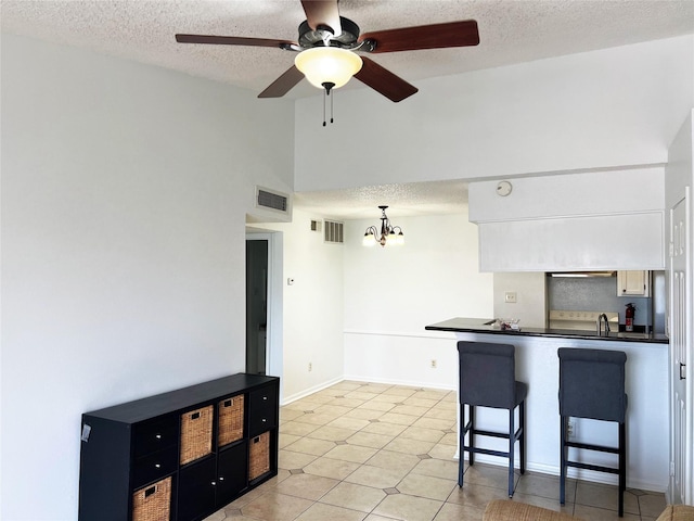 12550 Whittington Dr Unit 712, Houston, TX 77077 - kitchen with dark countertops, a chandelier, a ceiling fan, a breakfast bar area, and high vaulted ceiling
