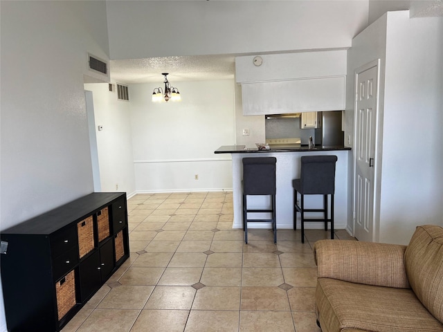 12550 Whittington Dr Unit 712, Houston, TX 77077 - kitchen with dark countertops, a chandelier, open floor plan, a peninsula, and a kitchen bar