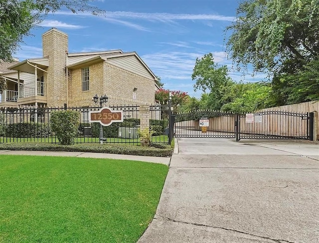 12550 Whittington Dr Unit 712, Houston, TX 77077 - view of property exterior with a gate, driveway, and a chimney