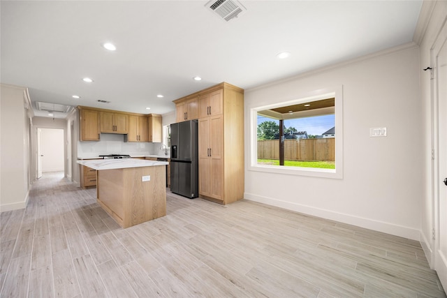 1041 Gardendale Dr, Houston, TX 77018 - kitchen featuring black refrigerator with ice dispenser, a center island, light countertops, baseboards, and recessed lighting