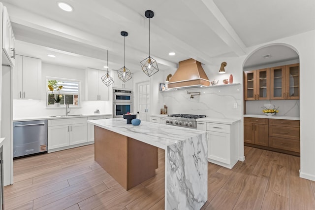 322 N Wilcrest Dr, Houston, TX 77079 - kitchen featuring stainless steel appliances, custom range hood, a center island, light wood-style flooring, and recessed lighting
