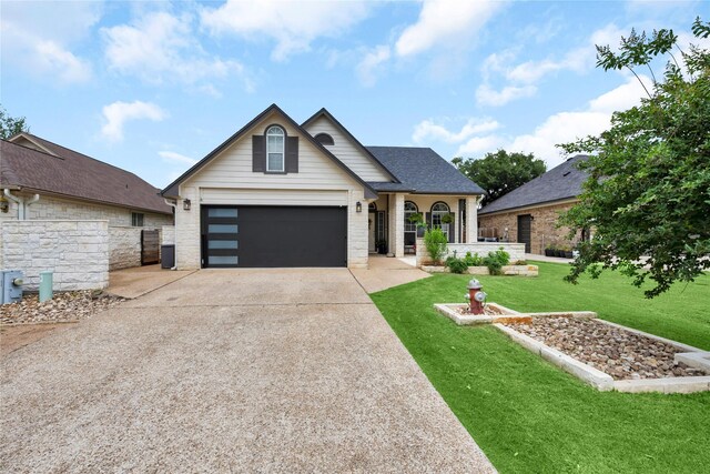 312 Fox Xing, Burnet, TX 78611 - view of front of house with a front lawn, concrete driveway, stone siding, and a shingled roof