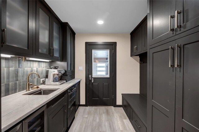 312 Fox Xing, Burnet, TX 78611 - kitchen featuring a sink, decorative backsplash, light wood-style flooring, light stone counters, and glass insert cabinets
